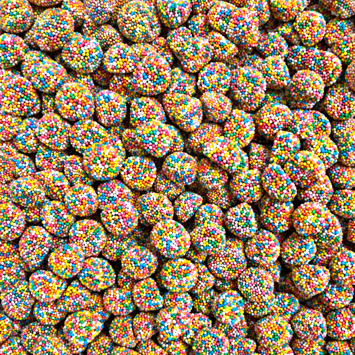 A close-up, top-down view of many small round candies coated in colorful sprinkles, filling the entire frame.